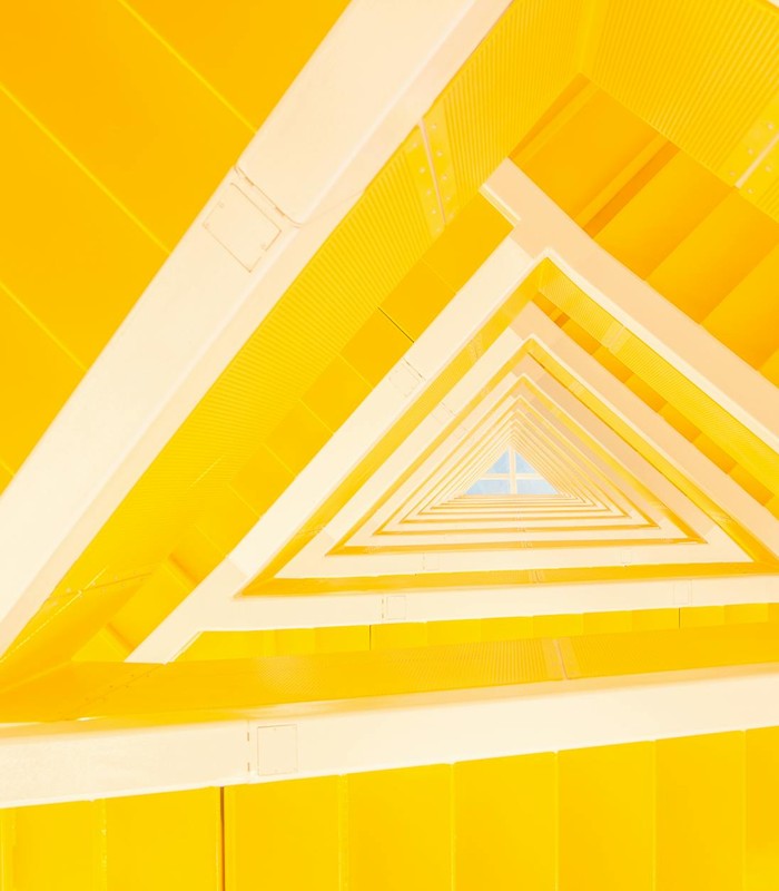 A modern abstract view of a yellow staircase with geometric lines and shapes.